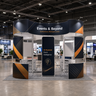 6x6m Island Booth with Curved Wall Panels & Display Shelving
