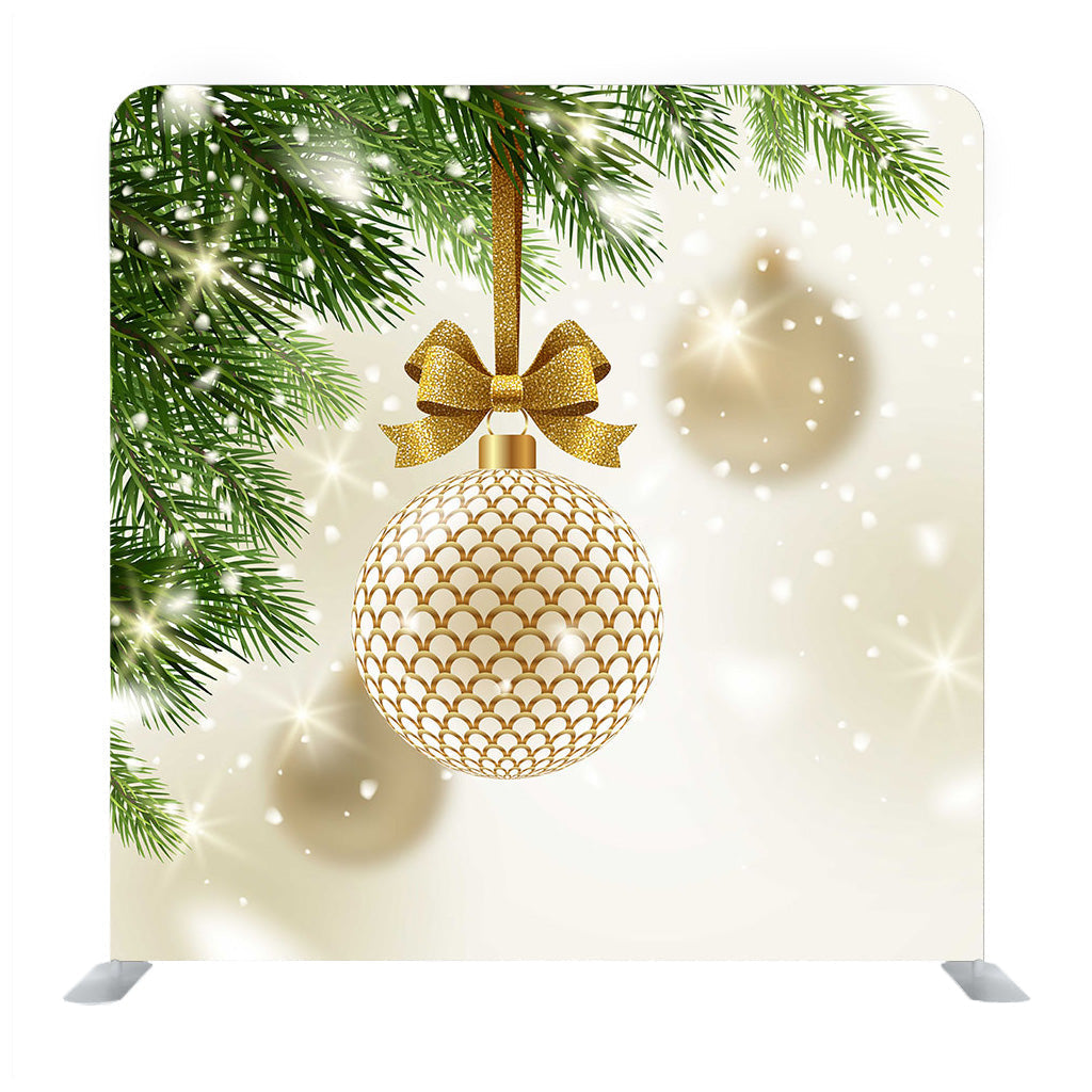 Gemusterte goldene Kugel mit glitzernder goldener Schleife, die an einer Weihnachtsbaum-Medienwand hängt